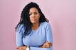 © Krakenimages.com - Middle age hispanic woman standing over pink background shaking and freezing for winter cold with sad and shock expression on face