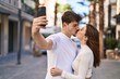 © Krakenimages.com - Mand and woman couple hugging each other make selfie by smartphone at street