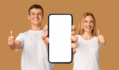 Canvas Print - Man And Woman Showing Smartphone With Big Blank White Screen At Camera