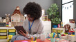 © Krakenimages.com - African american woman preschool teacher smiling confident writing on touchpad at kindergarten