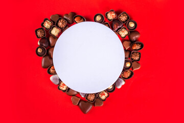 Sticker - Valentines Day chocolates banner, background, frame. Various sweets and chocolate candy on red paper background with copy space. Romantic composition. Happy Valentine's day greeting card background