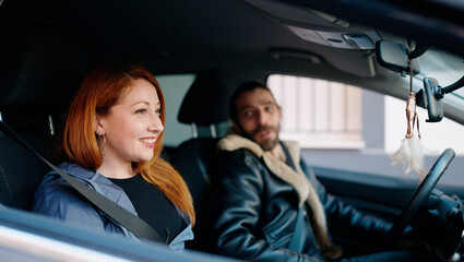 Wall Mural - Man and woman couple smiling confident driving car at street