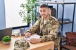 © Krakenimages.com - Young hispanic man army soldier signing contract at office
