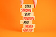 Never give up symbol. Concept words Stay strong stay positive never give up on wooden blocks. Beautiful orange background. Copy space. Businessman hand. Motivational business never give up concept.