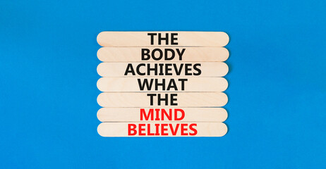 Mind and body symbol. Concept words The body achieves what the mind believes on wooden stick. Beautiful blue table blue background. Copy space. Motivational mind and body concept.
