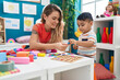 © Krakenimages.com - Teacher and toddler playing with maths puzzle game sitting on table at kindergarten
