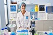 © Krakenimages.com - Brunette woman working at scientist laboratory winking looking at the camera with sexy expression, cheerful and happy face.