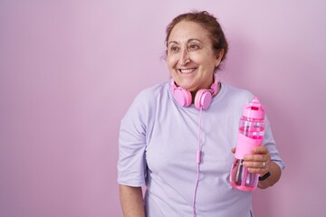 Poster - Senior woman wearing sportswear and headphones smiling looking to the side and staring away thinking.