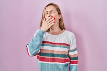 Poster - Young blonde woman standing over pink background bored yawning tired covering mouth with hand. restless and sleepiness.