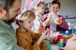 © Halfpoint - Happy family with little kids decorating easter eggs.