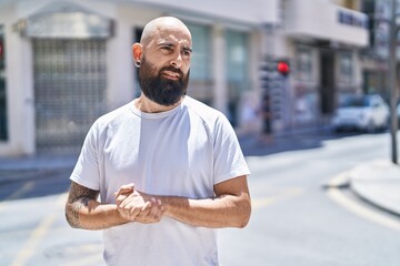 Canvas Print - Young bald man looking to the side with serious expression at street