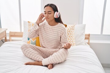 Wall Mural - Young beautiful hispanic woman doing yoga exercise sitting on bed at bedroom