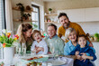 © Halfpoint - Portrait of happy multigenerational family during Easter dinner.