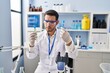 © Krakenimages.com - Young hispanic man scientist holding test tubes at laboratory