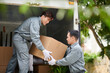 © DragonImages - Team of movers loading truck with cardboard boxes of client