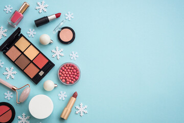 Fototapete - Winter cosmetic. Make up products and christmas decorations on blue background. Flat lay image with copy space.