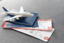 Toy Airplane And Passport With Tickets On Gray Background, Top View