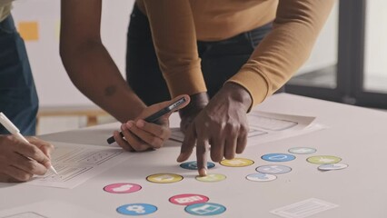 Wall Mural - Cropped shot of unrecognizable mobile app developers discussing project and drawing sketches at office table