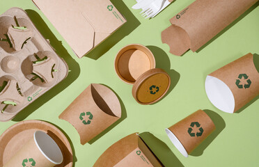 disposable eco-friendly packaging with a recycling sign on a green background. reusable raw material