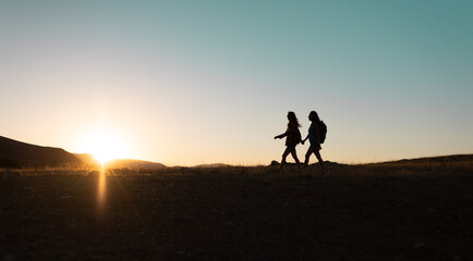 Wall Mural - two people walk along a mountain range