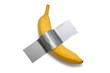 © halcon1 - Banana taped with dact gray tape to a white wall. A conceptual look at contemporary art. Ripe banana duct taped to white isolated background