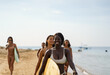© Jovo Jovanovic/Stocksy - Group of surfers walk down beach together