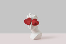 White Antique Bust With Red Paper Hearts Eyes.