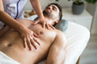 © David Prado/Stocksy - Crop masseuse massaging chest of client