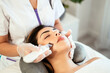 © David Prado/Stocksy - Cosmetologist giving facial cleaning to client