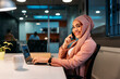 © VICTOR TORRES/Stocksy - Smiling Muslim employee speaking on smartphone and looking at camera