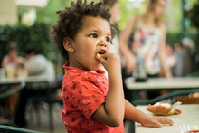 Toddler With Curly Hair Eating Fries