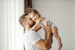 © Dusan Petkovic - A father is lifting his baby in the air and playing games while she is laughing at the camera and having fun.