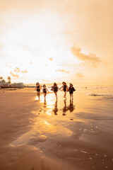 Wall Mural - a group of Asian teenagers running with happy expressions on vacation with their friends drunk on the beach