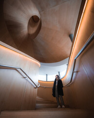girl standing on wooden spiral staircase