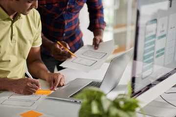 Wall Mural - front end developer writing ideas on sticky notes when talking to ux designer