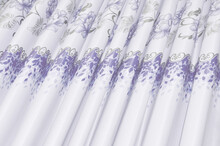 Close-up Of The Purple Floral Motif Of The Curtain Fabric In A Slanted Photo