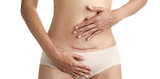 Fototapeta Tulipany - Closeup of woman belly with a scar from a cesarean section with her hands on white background