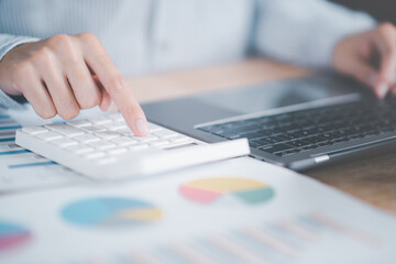 Fototapete - accountant calculating figures in company financial documents with a calculator,analysis of company financial data,Planning to assess and review budgets,concept of finance and investment,annual tax