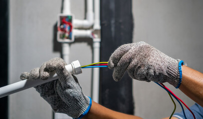 Electrician pulling wire into PVC Conduit.