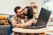© Mediteraneo - Young couple relaxing on sofa with laptop.Love,happiness,people and fun concept.