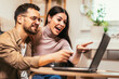 © Mediteraneo - Young couple relaxing on sofa with laptop.Love,happiness,people and fun concept.