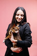© nazariykarkhut - Wonderful european female model chilling in studio with puppy. Indoor portrait of debonair girl enjoying photoshoot with her cute pet.