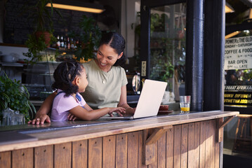 Wall Mural - Black family, coffee shop or laptop with a mother and daughter together in the window of a restaurant. Kids, computer or education with a woman and female child sitting or bonding in a internet cafe