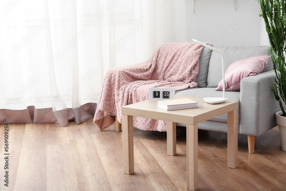 Interior of cozy living room with grey sofa and table