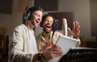 © N Felix/peopleimages.com - Music, singing and men recording in studio tablet, streaming with microphone, headphones and talent. Technology, art and creative influencer band and musician with live stream song for record label.