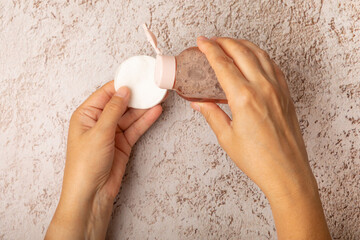 Wall Mural -  Female hands with a bottle of micellar water and a cotton pad. Makeup removal. Means for removing cosmetics and skin sebium. Tonic.