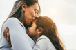 Happy latin mother and daughter having tender moment together outdoor - Mom day and love concept - Focus on mom eye