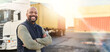 © Chanel M/peopleimages.com - Man, portrait and arms crossed by truck, container stack and happy for transport job. Driver, smile and shipping cargo freight with happiness in transportation service, stock delivery or supply chain