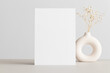 White invitation card mockup with a gypsophila on the beige table. 5x7 ratio, similar to A6, A5.