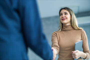 Smiling businesswoman shaking hands with a coworker during a meeting